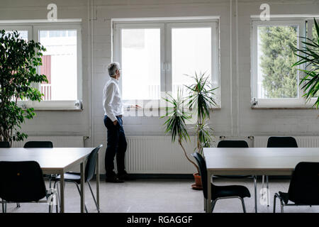 Imprenditore prendendo una pausa, guardando fuori della finestra Foto Stock