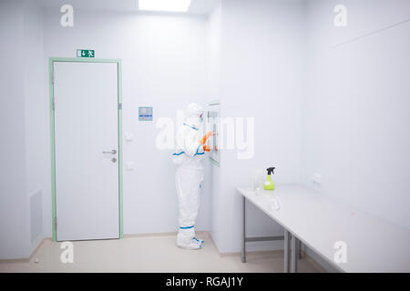 Tecnico di laboratorio per camera bianca di usura generale a materiale chiusa Foto Stock