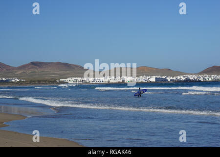 Surfer mit Surfbrett, Playa de Famara, Lanzarote, Kanarische isole, Spanien Foto Stock