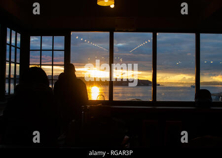 SEATTLE, NELLO STATO DI WASHINGTON - Gennaio 2019 - persone sconosciute all'interno di Pike Place Market guardando dal tramonto sulla baia di Elliot, Puget Sound a Seattle, Wa Foto Stock