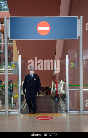 23.12.2017, Osaka, Giappone, Asia - un aeroporto in uniforme dipendente su una scala mobile presso l'Aeroporto Internazionale di Kansai. Foto Stock