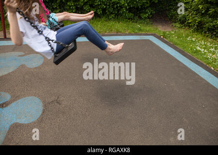 Due ragazze caucasion giocando su oscilla in un parco in un parco giochi Foto Stock