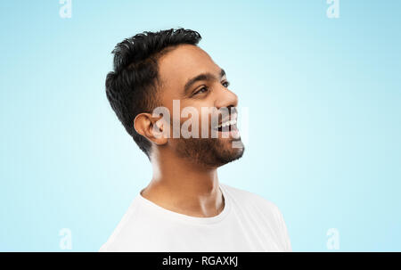 Giovani ridere uomo indiano su sfondo grigio Foto Stock