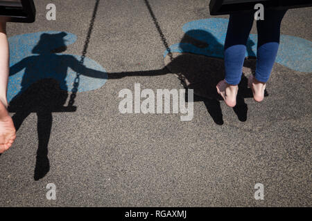 Due ragazze caucasion giocando su oscilla in un parco in un parco giochi Foto Stock