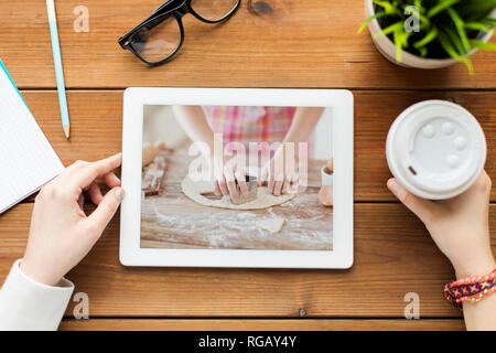 La donna guarda il video di cottura sul tablet pc Foto Stock