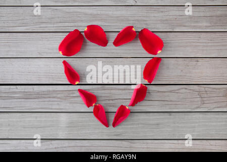 A forma di cuore ad cornice fatta di rosso petali di rosa Foto Stock