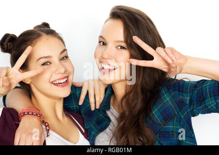 Felice ragazze adolescenti abbracciando e mostrando segno di pace Foto Stock