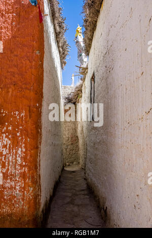 Small Alley tra bianco e arancione dipinto di case tradizionali dentro la città murata Foto Stock