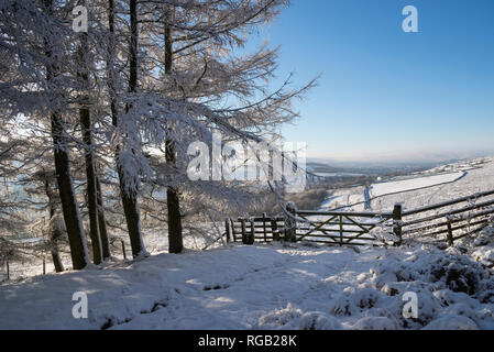 Cancello in un paesaggio innevato nelle colline del nord dell'Inghilterra. Il percorso che conduce alla cava Knarr, Tintwistle, Derbyshire, in Inghilterra. Foto Stock