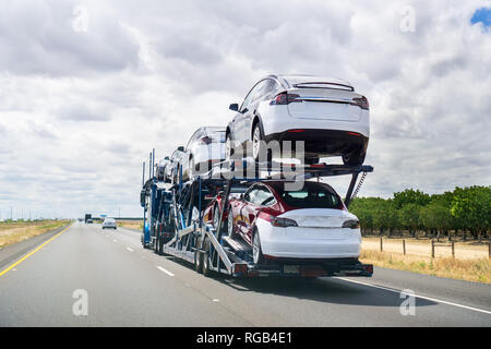 Maggio 25, 2018 Bakersfield / CA / STATI UNITI D'AMERICA - Car transporter porta Tesla Modello 3 nuovi veicoli lungo l autostrada, Vista posteriore del rimorchio Foto Stock