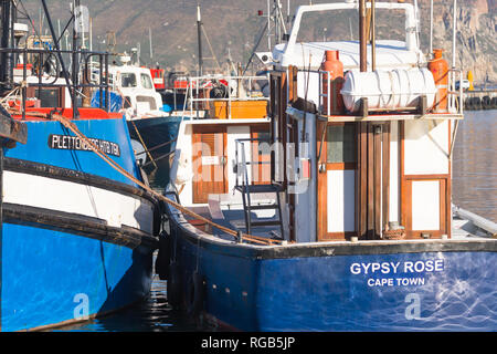 Hout Bay Harbor con la pesca industriale barche da vicino e legati assieme ormeggiato al molo in un assolato pomeriggio autunnale Foto Stock