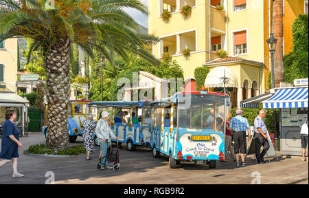 GARDONE RIVIERA, Italia - Settembre 2018: terra Turistica Treno nella piazza della città e nei pressi del terminal dei traghetti di Gardone Riviera sul lago di Garda. Foto Stock