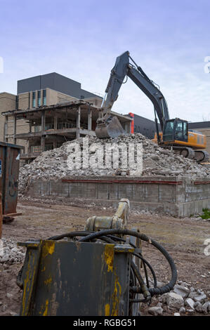 Un bulldozer è la demolizione di una parte di un edificio moderno in un gigantesco progetto di ristrutturazione, Ontario, Canada Foto Stock