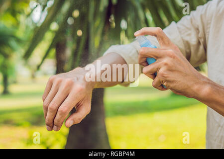 Giovane uomo zanzara di spruzzatura repellente per insetti in forrest, protezione dagli insetti Foto Stock