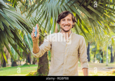 Giovane uomo zanzara di spruzzatura repellente per insetti in forrest, protezione dagli insetti Foto Stock