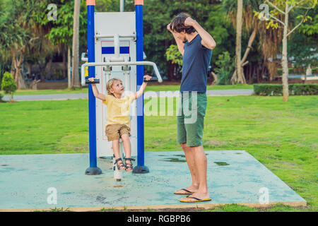 Padre e figlio nella palestra di strada nel parco Foto Stock