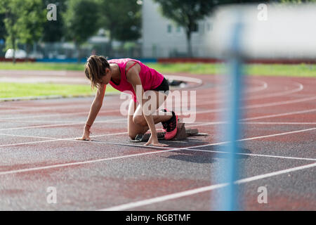 Runner adolescenti corsi di formazione inizia sulla pista Foto Stock