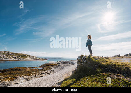 Finlandia, Lapponia, donna in piedi presso la costa in controluce Foto Stock