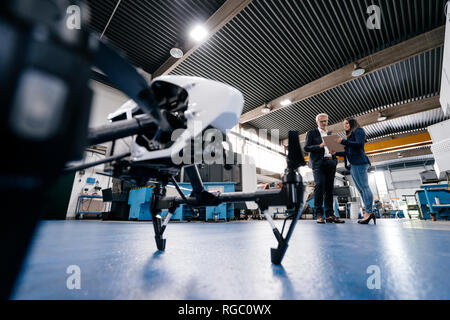 Imprenditore e collaboratore a discutere di produzione di fuchi Foto Stock