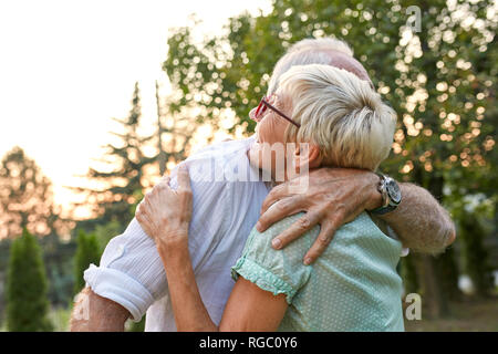 Felice coppia senior abbracciando all'aperto Foto Stock