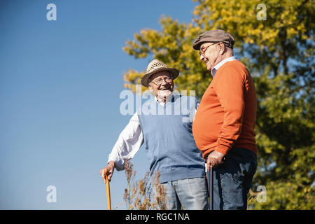 Due vecchi amici facendo una passeggiata attraverso i campi, parlando di vecchi tempi Foto Stock