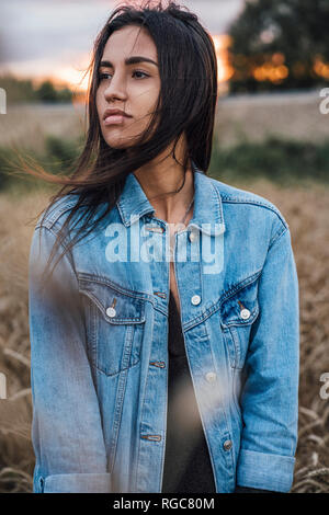 Ritratto di giovane donna indossando giacca denim Foto Stock