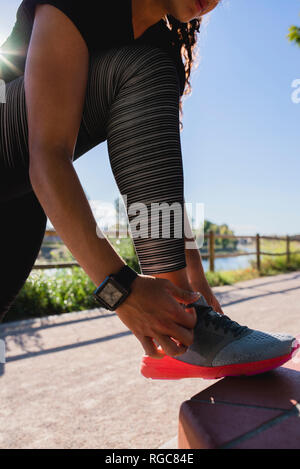 Legatura a donna la sua scarpa prima di allenamento Foto Stock