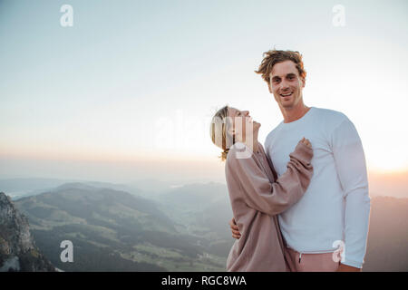 La Svizzera, Grosser Mythen, ritratto di felice coppia giovane in piedi in mountainscape presso sunrise Foto Stock