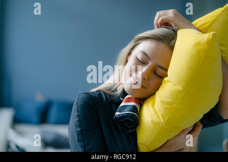 Ritratto di giovane sorridenti hostess con cuscino giallo Foto Stock