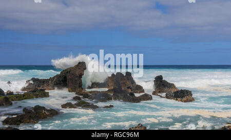 Un'onda si infrange contro le rocce a Ho'okipa beach sull'isola hawaiana di Maui Foto Stock