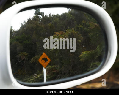 Inquadratura di un kiwi cartello stradale riflessa in uno specchio auto in Nuova Zelanda Foto Stock
