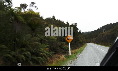 Una unità auto passato un kiwi cartello stradale in Nuova Zelanda Foto Stock