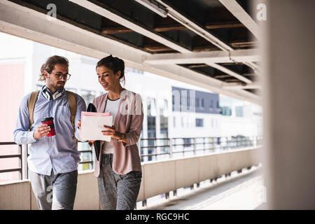 Young business persone per discutere il documento sulla loro wa al lavoro Foto Stock