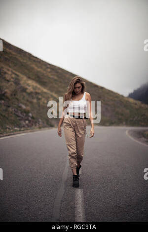 Donna bionda a camminare su una strada, persona sfocato Foto Stock