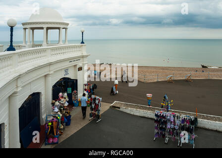 Una tipica località balneare inglese shop on Bexhill promenade con la spiaggia di ciottoli e mare in background; a seguito di pioggia. Foto Stock