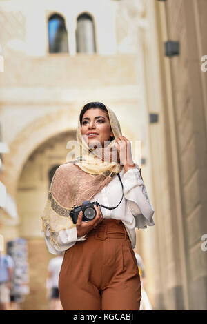 Spagna, Granada, giovane arabo tourist donna che indossa il hijab, utilizzo la fotocamera durante visite turistiche in città Foto Stock