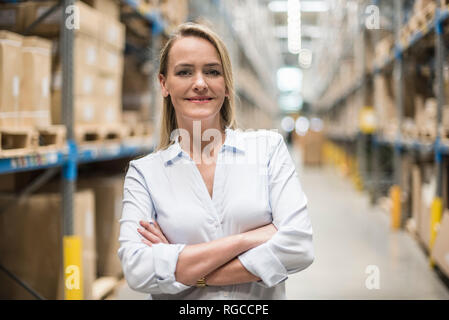 Ritratto di donna sorridente nel magazzino di fabbrica Foto Stock