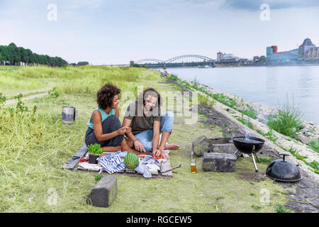 Germania, Colonia, giovane avente un barbecue al Riverside Foto Stock