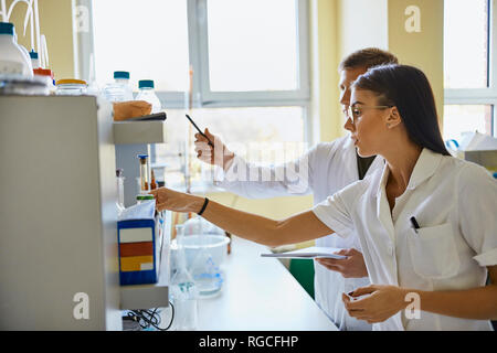Giovane uomo e donna che lavorano insieme in laboratorio Foto Stock
