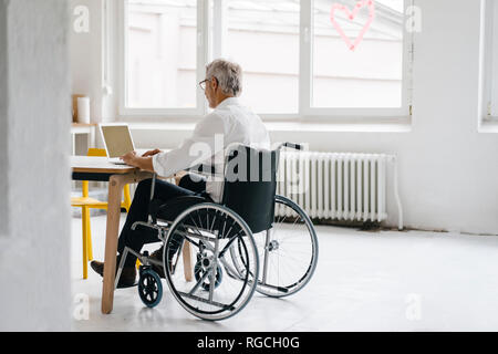 Manager di disabili in sedia a rotelle, lavoro in ufficio Foto Stock