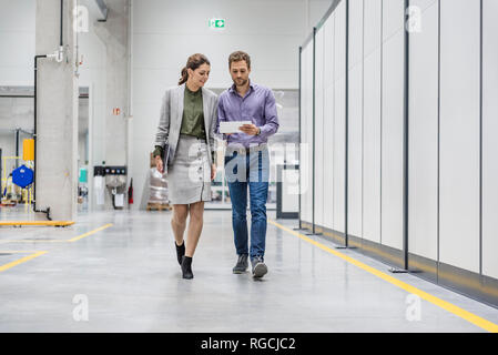 Imprenditore e la donna a camminare in compagnia, per discutere di nuove strategie Foto Stock