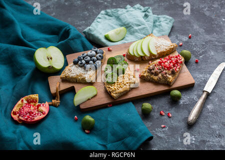 Fette di pane con vari ingredienti sulla tavola di legno Foto Stock