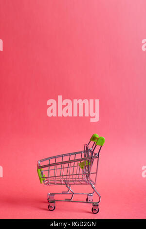 Miniatura carrello sul rosso. Lo shopping online concetto. La copia in bianco lo spazio per testo Foto Stock