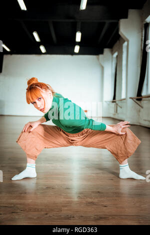 Bella slim yoga pulmann in un verde turtleneck cercando focalizzata Foto Stock