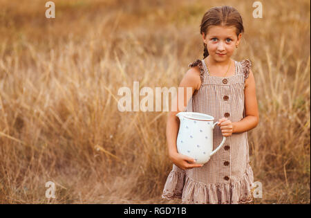 Bambina con un vasetto di latte nel counrtyside. Foto Stock