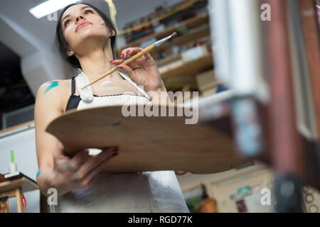 Donna artista pittura immagine in arte studio. Artista femminile, processo di disegno. Foto Stock