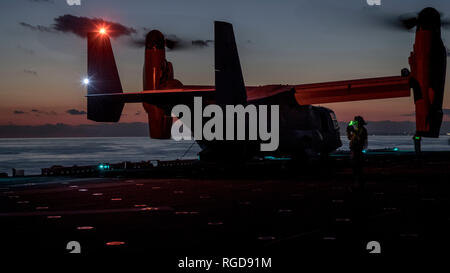 190128-N-ZL062-1237 Mare delle Filippine (GEN. 28, 2019) un marinaio dirige una MV-22B Osprey tiltrotor aeromobili, assegnato a mezzo marino Tiltrotor Squadron (VMM) 262 (rinforzato) con l'avviato 31 Marine Expeditionary Unit (MEU), di atterrare sul ponte di volo dell'assalto anfibio nave USS Wasp (LHD 1) durante la notte le operazioni di volo. Wasp, ammiraglia della Vespa Anfibia Gruppo pronto, con avviato 31 MEU, è operativo nell'Indo-Pacifico regione per migliorare l'interoperabilità con i partner e servire come una pronta risposta in vigore per qualsiasi tipo di emergenza. (U.S. Navy foto di comunicazione di massa spe Foto Stock