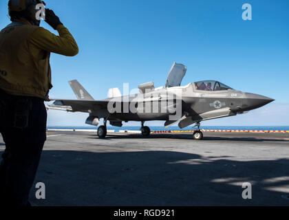 190128-N-SA412-1083 Mare delle Filippine (Jan 28, 2019) -- Aviazione di Boatswain Mate (movimentazione) terza classe Rulloda Noel, da Chicago, saluta il pilota di un F-35B Lightning II aeromobili appartenenti alle Marine Fighter Attack Squadron 121 prima che si toglie dal ponte di volo dell'assalto anfibio nave USS Wasp (LHD 1). Wasp, ammiraglia di Vespa Anfibia Gruppo pronto, con avviato 31 Marine Expeditionary Unit, è operativo nell'Indo-Pacifico regione per migliorare l'interoperabilità con i partner e servire come una pronta risposta in vigore per qualsiasi tipo di emergenza. (U.S. Navy foto di comunicazione di massa spe Foto Stock