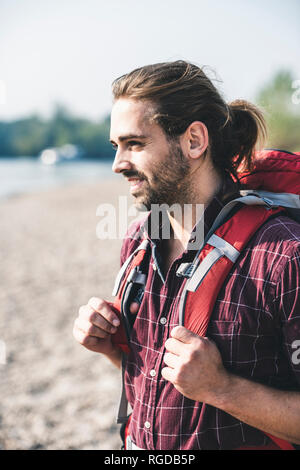Sorridente giovane con uno zaino all'aperto Foto Stock