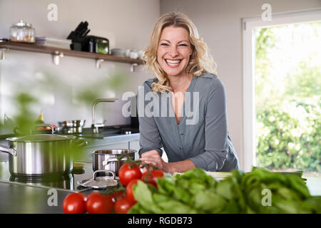 Ritratto di donna felice per la cottura in cucina Foto Stock